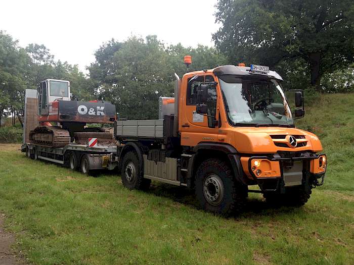 Unimog mit Raupenfahrzeug auf Anhänger